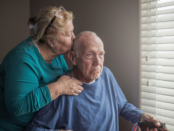 caregiver kisses man on the head