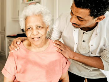caregiver embraces older woman