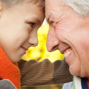 grandfather and grandson smile while touching foreheads