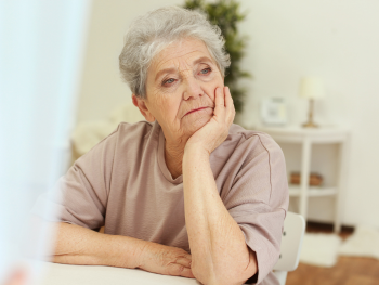 older woman looking pensively out a window