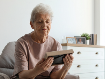 older woman gazing at framed photo