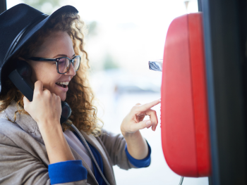 young woman uses payphone