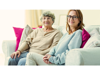 woman and elderly mother sit on a cozy couch