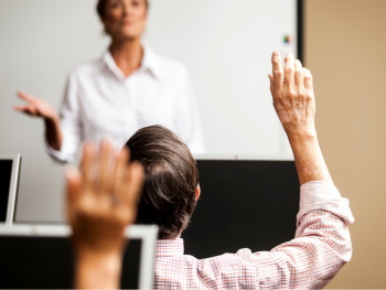 man raises his hand in a computer class