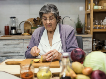 older woman cutting potatoes