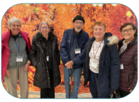 group of older adults in front of fall foliage