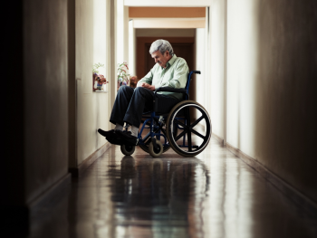 man in wheelchair sits in darkened hallway
