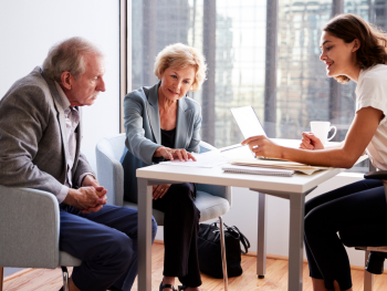 older couple meets with financial advisor in their office