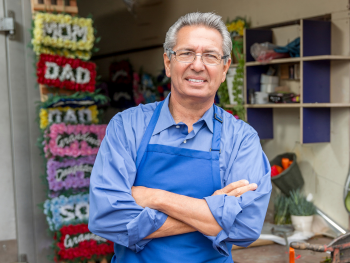 florist stands in front of display