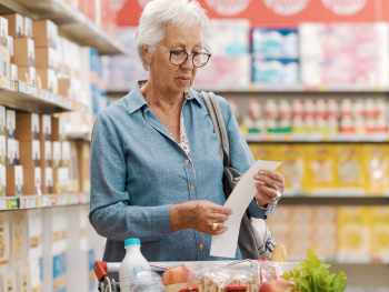 woman looking over grocery receipt