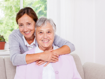 caregiver hugs older woman