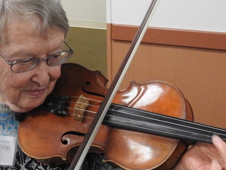 older woman playing violin