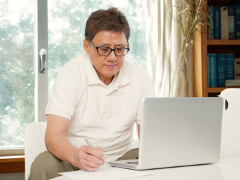man sitting with laptop in his home