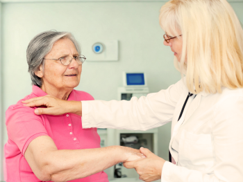 doctor checks older woman's shoulder