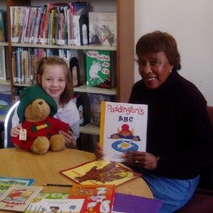 volunteer and child with Paddington book and stuffed animal