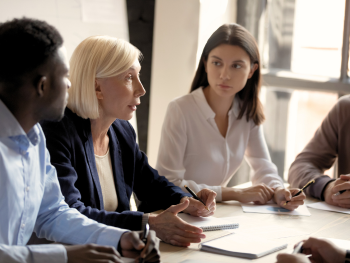 older worker holds attention of younger coworkers