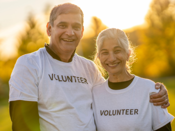 Two older adults wearing t-shirts that say "volunteer"