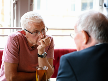 two older men sit at a table